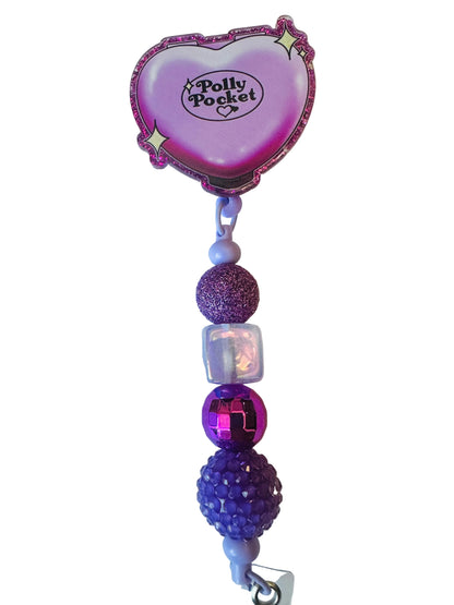 Purple heart-shaped clip with decorative beads on a white background