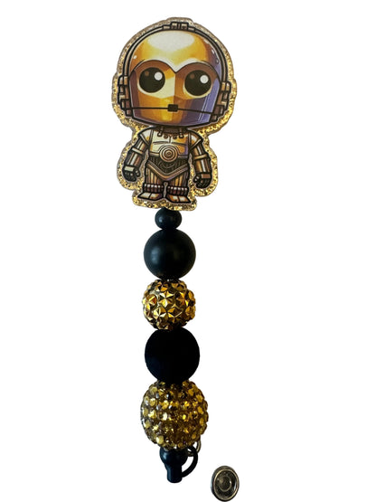 Decorative keychain with black and gold beads on a textured surface