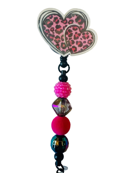 Beaded charm with a pink leopard print butterfly on a light background